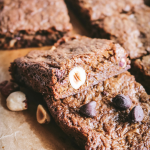 close up view of chewy whole wheat blondies with hazelnuts and chocolate chips.